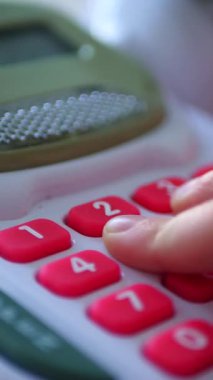 Dikey. Bir çocuğun elleri oyuncak kasasının renkli tuşlarına basıyor. Minyatür bir kasadaki düğmelere titizlikle basan bir çocuğun parmak görüntüsü. Çocuk yazar kasası.