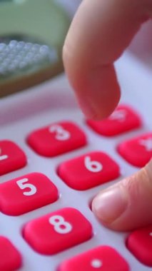 Dikey. Bir çocuğun elleri oyuncak kasasının renkli tuşlarına basıyor. Minyatür bir kasadaki düğmelere titizlikle basan bir çocuğun parmak görüntüsü. Çocuk yazar kasası.