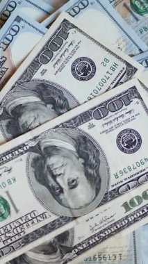 Dikey. Bir yığın gevrek, dolar banknotları, becerikli ellerde tutuluyor. Adam kağıt para sayıyor. Bir Amerikan para akışı. Bir sürü dolar. ABD banknotlarının yakın plan görüntüsü. İşadamı banknotları sayar