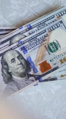 Dikey. Bir yığın gevrek, dolar banknotları, becerikli ellerde tutuluyor. Adam kağıt para sayıyor. Bir Amerikan para akışı. Bir sürü dolar. ABD banknotlarının yakın plan görüntüsü. İşadamı banknotları sayar
