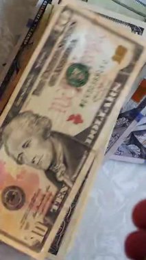 Dikey. Bir yığın gevrek, dolar banknotları, becerikli ellerde tutuluyor. Adam kağıt para sayıyor. Bir Amerikan para akışı. Bir sürü dolar. ABD banknotlarının yakın plan görüntüsü. İşadamı banknotları sayar