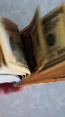 Dikey. Bir yığın gevrek, dolar banknotları, becerikli ellerde tutuluyor. Adam kağıt para sayıyor. Bir Amerikan para akışı. Bir sürü dolar. ABD banknotlarının yakın plan görüntüsü. İşadamı banknotları sayar