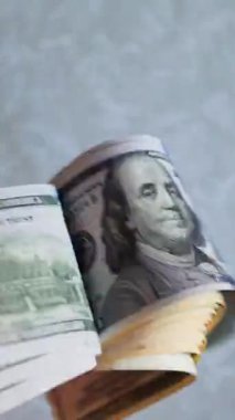 Dikey. Bir yığın gevrek, dolar banknotları, becerikli ellerde tutuluyor. Adam kağıt para sayıyor. Bir Amerikan para akışı. Bir sürü dolar. ABD banknotlarının yakın plan görüntüsü. İşadamı banknotları sayar