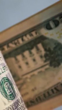Dikey. Bir yığın gevrek, dolar banknotları, becerikli ellerde tutuluyor. Adam kağıt para sayıyor. Bir Amerikan para akışı. Bir sürü dolar. ABD banknotlarının yakın plan görüntüsü. İşadamı banknotları sayar