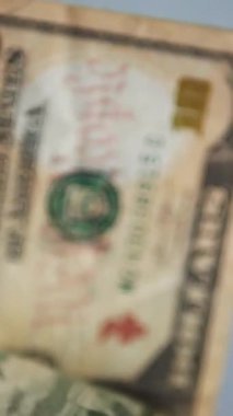 Dikey. Bir yığın gevrek, dolar banknotları, becerikli ellerde tutuluyor. Adam kağıt para sayıyor. Bir Amerikan para akışı. Bir sürü dolar. ABD banknotlarının yakın plan görüntüsü. İşadamı banknotları sayar