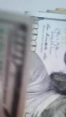 Dikey. Bir yığın gevrek, dolar banknotları, becerikli ellerde tutuluyor. Adam kağıt para sayıyor. Bir Amerikan para akışı. Bir sürü dolar. ABD banknotlarının yakın plan görüntüsü. İşadamı banknotları sayar