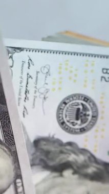 Dikey. Bir yığın gevrek, dolar banknotları, becerikli ellerde tutuluyor. Adam kağıt para sayıyor. Bir Amerikan para akışı. Bir sürü dolar. ABD banknotlarının yakın plan görüntüsü. İşadamı banknotları sayar