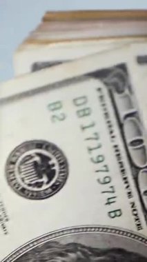 Dikey. Bir yığın gevrek, dolar banknotları, becerikli ellerde tutuluyor. Adam kağıt para sayıyor. Bir Amerikan para akışı. Bir sürü dolar. ABD banknotlarının yakın plan görüntüsü. İşadamı banknotları sayar