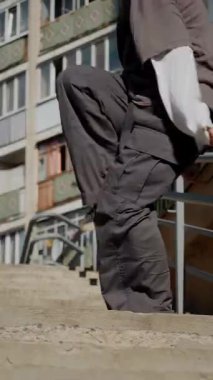 Dikey. Şehir koreografisi beton basamaklarda, zarafet ve güçle hareket eden bir kadın olarak gözler önüne seriliyor. Hip-hop hareketleri, şehir binalarına karşı bir enerji patlaması. Sokak stili dansla buluşur. Somut adımlar, hip-hop sanatının bir sahnesi., 