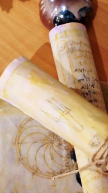 Dikey. Eski parşömen, zamana bağlı. Yıllanmış parşömenler ve mumlar. El yazmaları, antik belgeler, belgeler. Tarihi bir buluş, bir hazine. Kalem, çağların sırrı. Parşömenler, bir mum