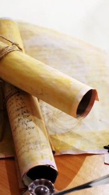 Dikey. Eski parşömen, zamana bağlı. Yıllanmış parşömenler ve mumlar. El yazmaları, antik belgeler, belgeler. Tarihi bir buluş, bir hazine. Kalem, çağların sırrı. Parşömenler, bir mum