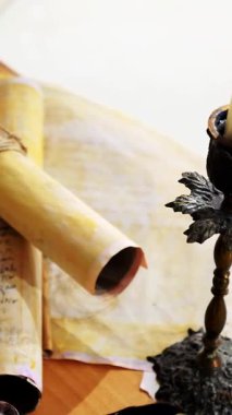 Dikey. Eski parşömen, zamana bağlı. Yıllanmış parşömenler ve mumlar. El yazmaları, antik belgeler, belgeler. Tarihi bir buluş, bir hazine. Kalem, çağların sırrı. Parşömenler, bir mum