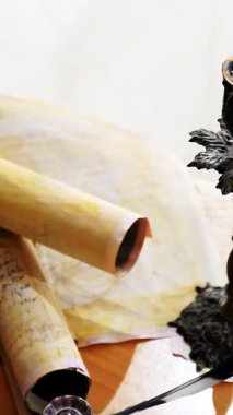 Dikey. Eski parşömen, zamana bağlı. Yıllanmış parşömenler ve mumlar. El yazmaları, antik belgeler, belgeler. Tarihi bir buluş, bir hazine. Kalem, çağların sırrı. Parşömenler, bir mum