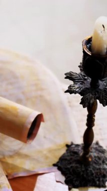 Dikey. Eski parşömen, zamana bağlı. Yıllanmış parşömenler ve mumlar. El yazmaları, antik belgeler, belgeler. Tarihi bir buluş, bir hazine. Kalem, çağların sırrı. Parşömenler, bir mum