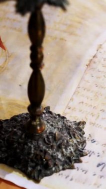 Dikey. Eski parşömen, zamana bağlı. Yıllanmış parşömenler ve mumlar. El yazmaları, antik belgeler, belgeler. Tarihi bir buluş, bir hazine. Kalem, çağların sırrı. Parşömenler, bir mum