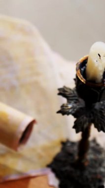 Dikey. Eski parşömen, zamana bağlı. Yıllanmış parşömenler ve mumlar. El yazmaları, antik belgeler, belgeler. Tarihi bir buluş, bir hazine. Kalem, çağların sırrı. Parşömenler, bir mum