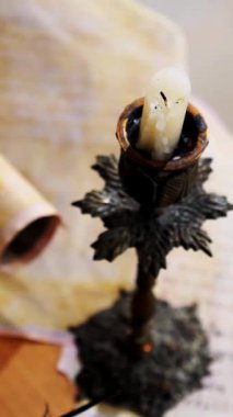 Dikey. Eski parşömen, zamana bağlı. Yıllanmış parşömenler ve mumlar. El yazmaları, antik belgeler, belgeler. Tarihi bir buluş, bir hazine. Kalem, çağların sırrı. Parşömenler, bir mum