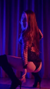 Dikey. Baştan çıkarıcı dans eden seksi kadın. Yüksek topuklu bir dansçı, canlı renklerle yıkanmış, sahnenin heyecan verici enerjisini somutlaştırıyor. Yüksek topuklular, burlesk performansı, striptiz...