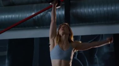 Spor salonunda egzersiz yapan kaslı bir kadın. Atletizm antrenmanı. Güzel vücudunu ve vücut şeklini gösteren güçlü atletik kadın..