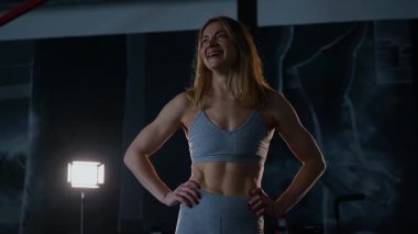 Spor salonunda egzersiz yapan kaslı bir kadın. Atletizm antrenmanı. Güzel vücudunu ve vücut şeklini gösteren güçlü atletik kadın..