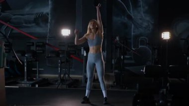 Spor salonunda egzersiz yapan kaslı bir kadın. Atletizm antrenmanı. Güzel vücudunu ve vücut şeklini gösteren güçlü atletik kadın..