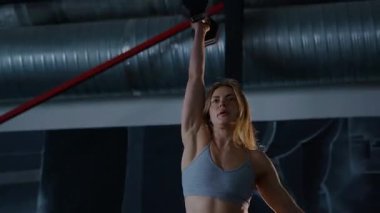 Spor salonunda egzersiz yapan kaslı bir kadın. Atletizm antrenmanı. Güzel vücudunu ve vücut şeklini gösteren güçlü atletik kadın..