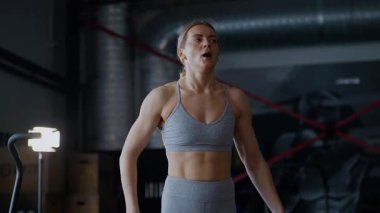 Spor salonunda egzersiz yapan kaslı bir kadın. Atletizm antrenmanı. Güzel vücudunu ve vücut şeklini gösteren güçlü atletik kadın..