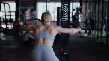 Spor salonunda egzersiz yapan kaslı bir kadın. Atletizm antrenmanı. Güzel vücudunu ve vücut şeklini gösteren güçlü atletik kadın..