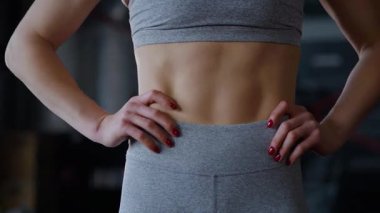 Spor salonunda egzersiz yapan kaslı bir kadın. Atletizm antrenmanı. Güzel vücudunu ve vücut şeklini gösteren güçlü atletik kadın..