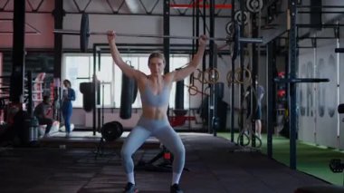 Spor salonunda egzersiz yapan kaslı bir kadın. Atletizm antrenmanı. Güzel vücudunu ve vücut şeklini gösteren güçlü atletik kadın..