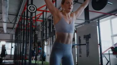 Spor salonunda egzersiz yapan kaslı bir kadın. Atletizm antrenmanı. Güzel vücudunu ve vücut şeklini gösteren güçlü atletik kadın..