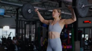 Spor salonunda egzersiz yapan kaslı bir kadın. Atletizm antrenmanı. Güzel vücudunu ve vücut şeklini gösteren güçlü atletik kadın..