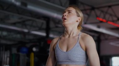 Spor salonunda egzersiz yapan kaslı bir kadın. Atletizm antrenmanı. Güzel vücudunu ve vücut şeklini gösteren güçlü atletik kadın..