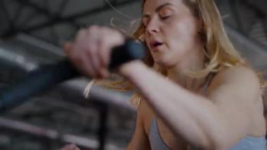 Spor salonunda egzersiz yapan kaslı bir kadın. Atletizm antrenmanı. Güzel vücudunu ve vücut şeklini gösteren güçlü atletik kadın..