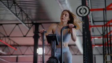 Spor salonunda egzersiz yapan kaslı bir kadın. Atletizm antrenmanı. Güzel vücudunu ve vücut şeklini gösteren güçlü atletik kadın..