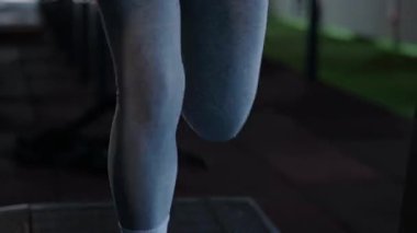 Spor salonunda egzersiz yapan kaslı bir kadın. Atletizm antrenmanı. Güzel vücudunu ve vücut şeklini gösteren güçlü atletik kadın..