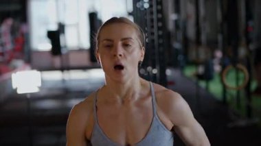 Spor salonunda egzersiz yapan kaslı bir kadın. Atletizm antrenmanı. Güzel vücudunu ve vücut şeklini gösteren güçlü atletik kadın..