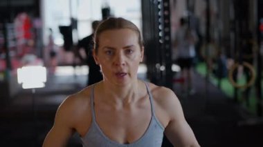 Spor salonunda egzersiz yapan kaslı bir kadın. Atletizm antrenmanı. Güzel vücudunu ve vücut şeklini gösteren güçlü atletik kadın..