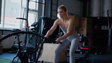 Spor salonunda egzersiz yapan kaslı bir kadın. Atletizm antrenmanı. Güzel vücudunu ve vücut şeklini gösteren güçlü atletik kadın..