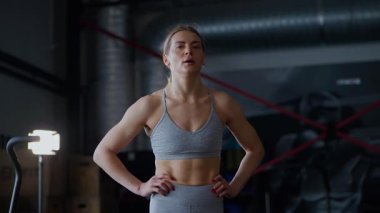 Spor salonunda egzersiz yapan kaslı bir kadın. Atletizm antrenmanı. Güzel vücudunu ve vücut şeklini gösteren güçlü atletik kadın..