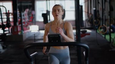 Spor salonunda egzersiz yapan kaslı bir kadın. Atletizm antrenmanı. Güzel vücudunu ve vücut şeklini gösteren güçlü atletik kadın..