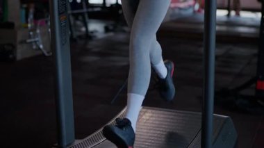 Spor salonunda egzersiz yapan kaslı bir kadın. Atletizm antrenmanı. Güzel vücudunu ve vücut şeklini gösteren güçlü atletik kadın..