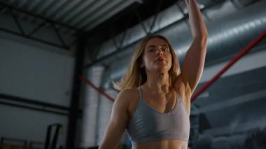 Spor salonunda egzersiz yapan kaslı bir kadın. Atletizm antrenmanı. Güzel vücudunu ve vücut şeklini gösteren güçlü atletik kadın..