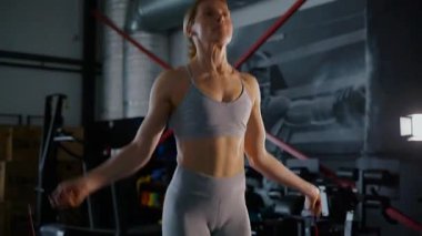 Spor salonunda egzersiz yapan kaslı bir kadın. Atletizm antrenmanı. Güzel vücudunu ve vücut şeklini gösteren güçlü atletik kadın..