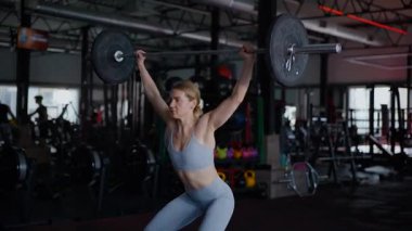 Spor salonunda egzersiz yapan kaslı bir kadın. Atletizm antrenmanı. Güzel vücudunu ve vücut şeklini gösteren güçlü atletik kadın..