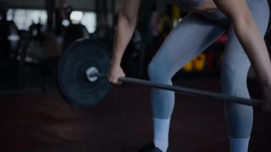 Spor salonunda egzersiz yapan kaslı bir kadın. Atletizm antrenmanı. Güzel vücudunu ve vücut şeklini gösteren güçlü atletik kadın..