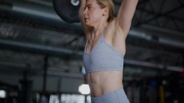 Spor salonunda egzersiz yapan kaslı bir kadın. Atletizm antrenmanı. Güzel vücudunu ve vücut şeklini gösteren güçlü atletik kadın..