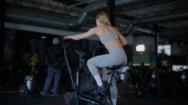 Spor salonunda egzersiz yapan kaslı bir kadın. Atletizm antrenmanı. Güzel vücudunu ve vücut şeklini gösteren güçlü atletik kadın..