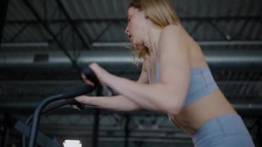 Spor salonunda egzersiz yapan kaslı bir kadın. Atletizm antrenmanı. Güzel vücudunu ve vücut şeklini gösteren güçlü atletik kadın..