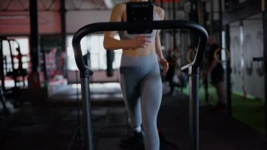 Spor salonunda egzersiz yapan kaslı bir kadın. Atletizm antrenmanı. Güzel vücudunu ve vücut şeklini gösteren güçlü atletik kadın..